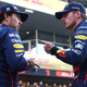 Sergio Perez and Max Verstappen talking with each other in front of their team's garage